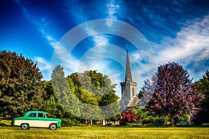 View of a Ford Consul Mk1 parked in the greenery before the old English church photo