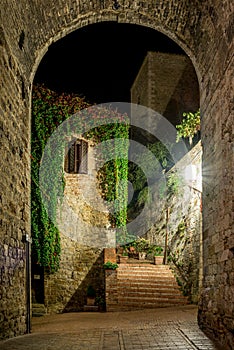 View of a foreshortening through an arch in San Gimignano in Tuscany by night photo