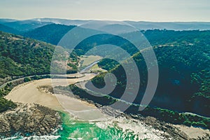 View of forested hills and ocean coastline.