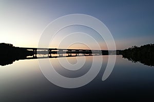 View of Fort Hamer Bridge under the blue sky reflected in the water at sunset