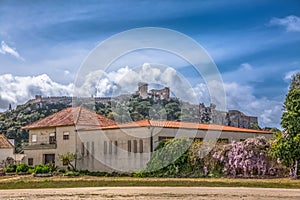 View of the fortress and Luso Roman castle of Ã“bidos, with buildings of Portuguese vernacular architecture and sky with clouds,