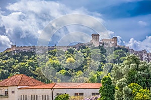 View of the fortress and Luso Roman castle of Ã“bidos, with buildings of Portuguese vernacular architecture and sky with clouds,