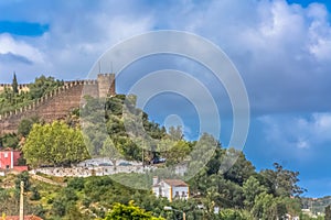 View of the fortress and Luso Roman castle of Ã“bidos, with buildings of Portuguese vernacular architecture and sky with clouds,