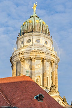 View on French Cathedral with red tiled roof in foreground at Gendarmenmarkt square in Berlin, Germany