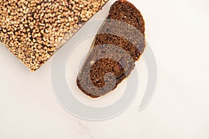 View of fresh brown bread slice and loaf on white background