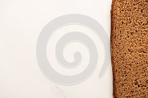 View of fresh brown bread slice on white background with copy space