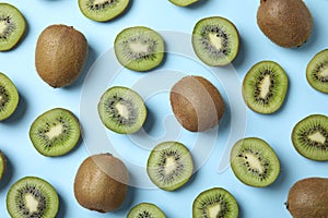 view of fresh whole and cut kiwis on light blue background