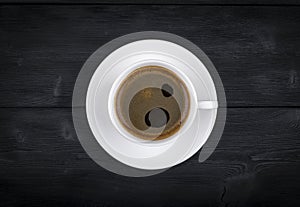 view of a freshly brewed mug of espresso coffee on rustic wooden background with woodgrain texture. Coffee break style, concept.