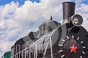 View of the front of the old steam locomotive with the smokestack, headlight and smokebox door