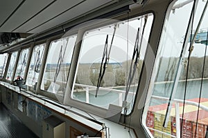 View from front windows with windscreen wipers of navigational bridge of container vessel.