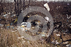 View of a garbage, plastic, bags and polyester spread and discarded in the dry grass in field. Concept about ecology.