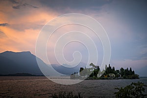 View of Garda Lake and San Biagio island at sunset in Manerba del Garda, Italy