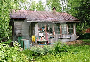 View from garden to terrace with kitchen utensils of old wooden house