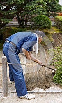 View of gardener with blue uniform work on Ginshadan sand layout