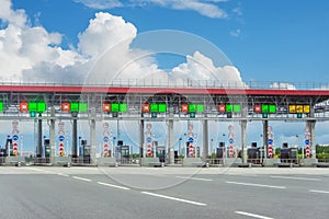 View gate for cars at the entrance to the toll road, limited by the barrier. Cashless payment transponder, speed limit signs