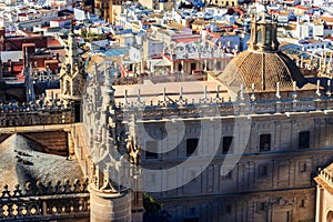 View from the Giralda Tower out over the roof and spires of Seville cathedral with the city in view in Seville, Spain