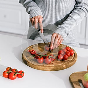 View of girl cutting red cherry tomatoes
