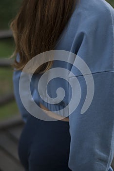 View of a girl's athletic body in blue gym suit in the park