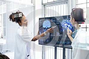 View through glass, Team doctor presentation of brain x-ray results through screen to present to medical team in meeting room.