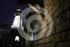 View of glowing lantern on wall of brick building