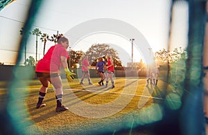 View Through Goal Net Of Womens Football Team Playing Soccer Match