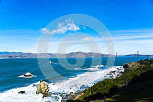 The view of golden gate bridge in Lands end at San Francisco- San Francisco. summer , cloud , rock , sea, plant.