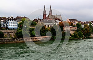 View of the Gothic red brick Basel Cathedral and the embankment of the Rhein River in the city of Basel, Switzerland