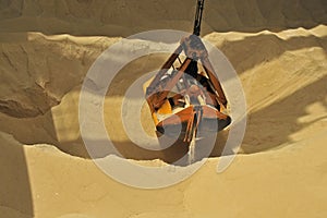 View of grab bucket digging sand in a sand pit