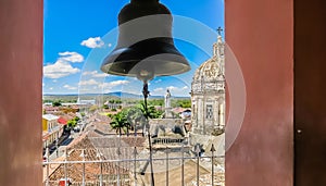 View of the Granada city through the arch of the bell tower of La Merced Church along the street Calle Real Xalteva with Iglesia