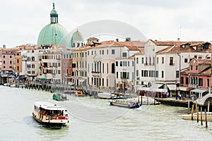 View of the Grand Canal of Venice, Italy. Boat sails on the water with tourists, summer day.