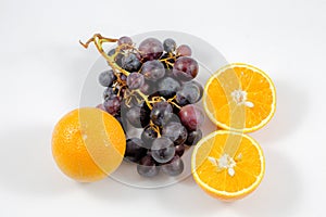 View of grapes and oranges in a white background/fruits/orange/fresh/grapes