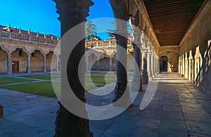 View of the grassed cloister of the University of Salamanca from the corridors with the shadows and silhouettes by the evening