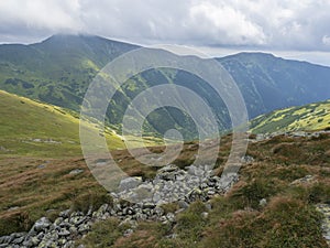 View from grassy hill slopes of hiking trail from Chopok at mountain meadow landscape of ridge Low Tatras mountains