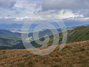 View from grassy hill slopes of hiking trail from Chopok at mountain meadow landscape of ridge Low Tatras mountains