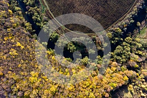 View from a great height on the bend of the river surrounded by autumn forest