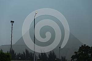 View of the Great Pyramid from an interesting perspective on a foggy morning in Giza, Cairo