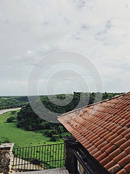 View at green fields of altos de chavon from the red roof of antique-like building