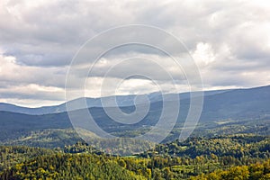 A view of green fields, forests and mountains in the Giant Mountains from above.