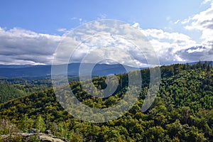 A view of green fields, forests and mountains in the Giant Mountains from above.