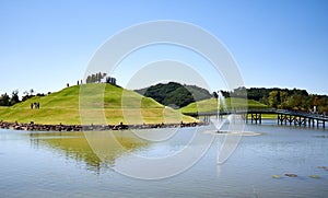 View of green hill and water fountain at a lake at Suncheonman National Garden in South Korea