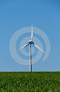 View of green meadows and fields with a wind turbine to generate electricity near Freital Dresden,Germany