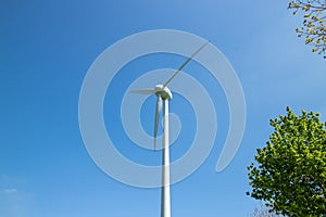 View of green meadows and fields with a wind turbine to generate electricity near Freital Dresden,Germany