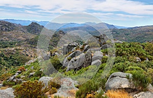 View of green mountains and stones from the ruins of Castro Laboreiro castle in Portugal photo