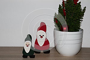 View on a green santa claus and a red santa claus next to a little decorated tree at home in niederlangen emsland germany