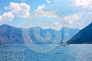 View of green wooded mountains and blue sea, blue sky and white clouds.