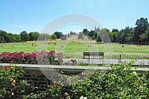 View of Greenwich Park with unidentified people sunbathing on the grass and the Royal Observatory up on the hill in London, UK.