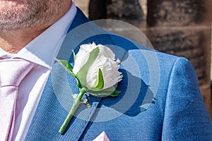View of a groom wearing an artificial rose buttonhole
