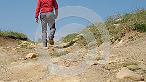 View from ground level of man walking rugged road of Nebrodi Park,