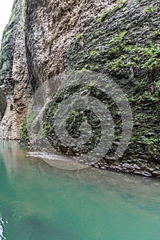 View of the GuadalevÃ­n River with its turquoise waters and the rocky hillside with green plants or moss