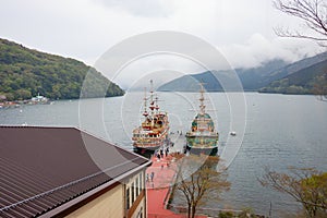 View of Hakone sightseeing cruise pirate ships docks on pier of Togendai Station at Lake Ashi.